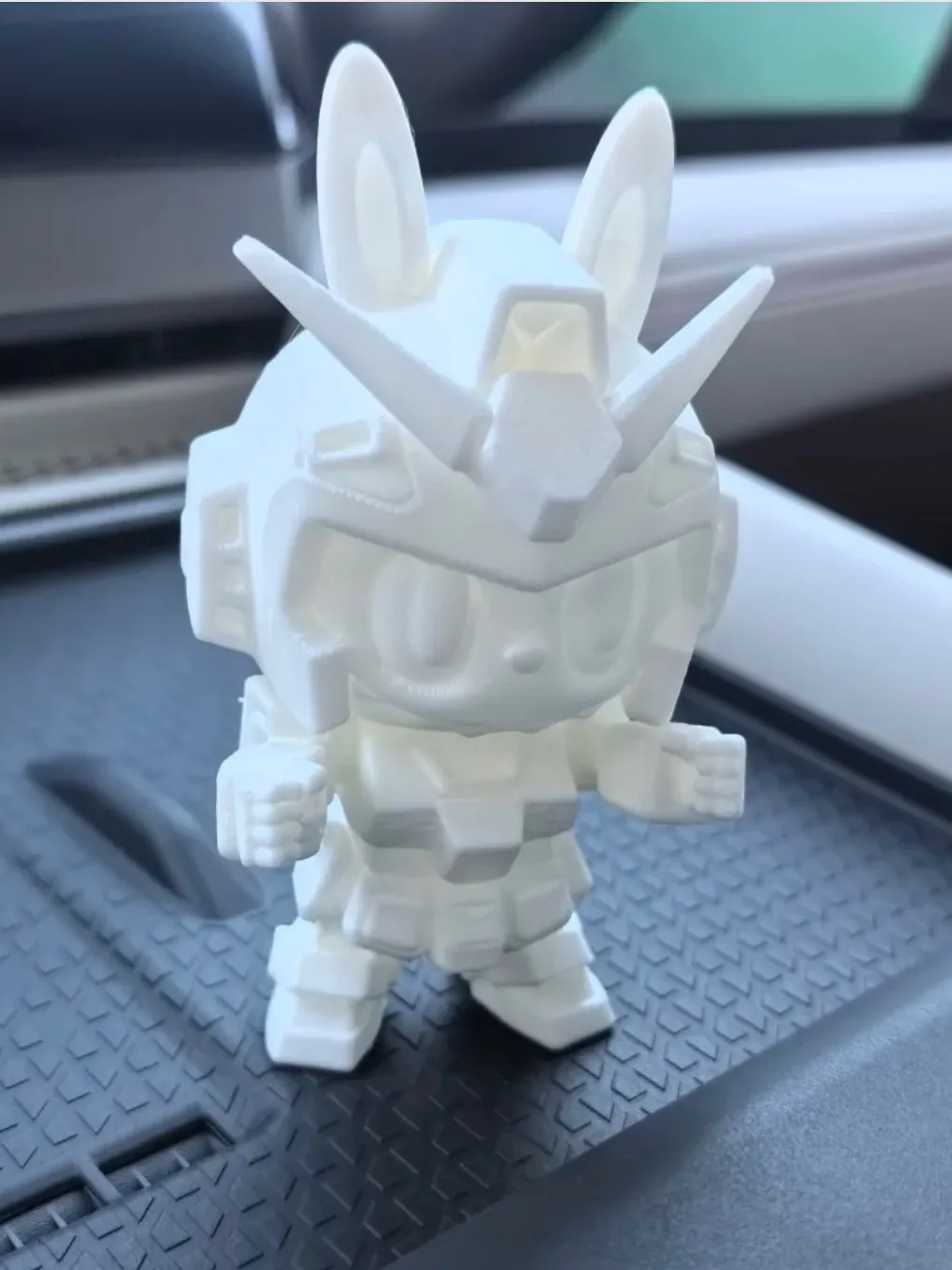 PLA Basic Jade White filament 3D printed robot-style figure placed on a car interior surface
