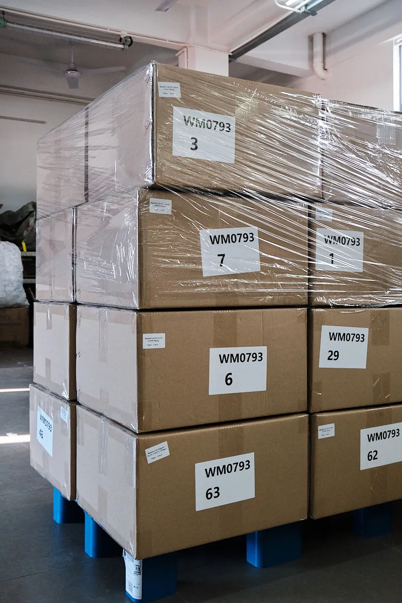 Palletized rectangular cartons stacked at a 45-degree angle, each box clearly labeled for identification