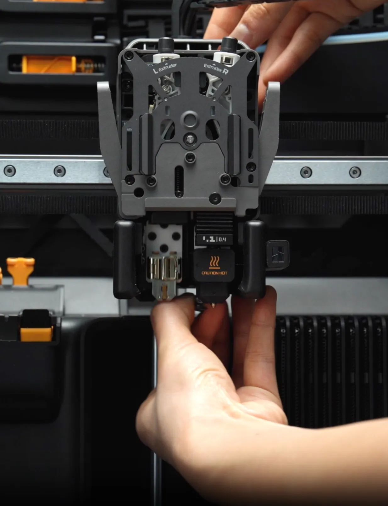 User pulling down the quick swap nozzle module from a Bambu Lab hotend assembly