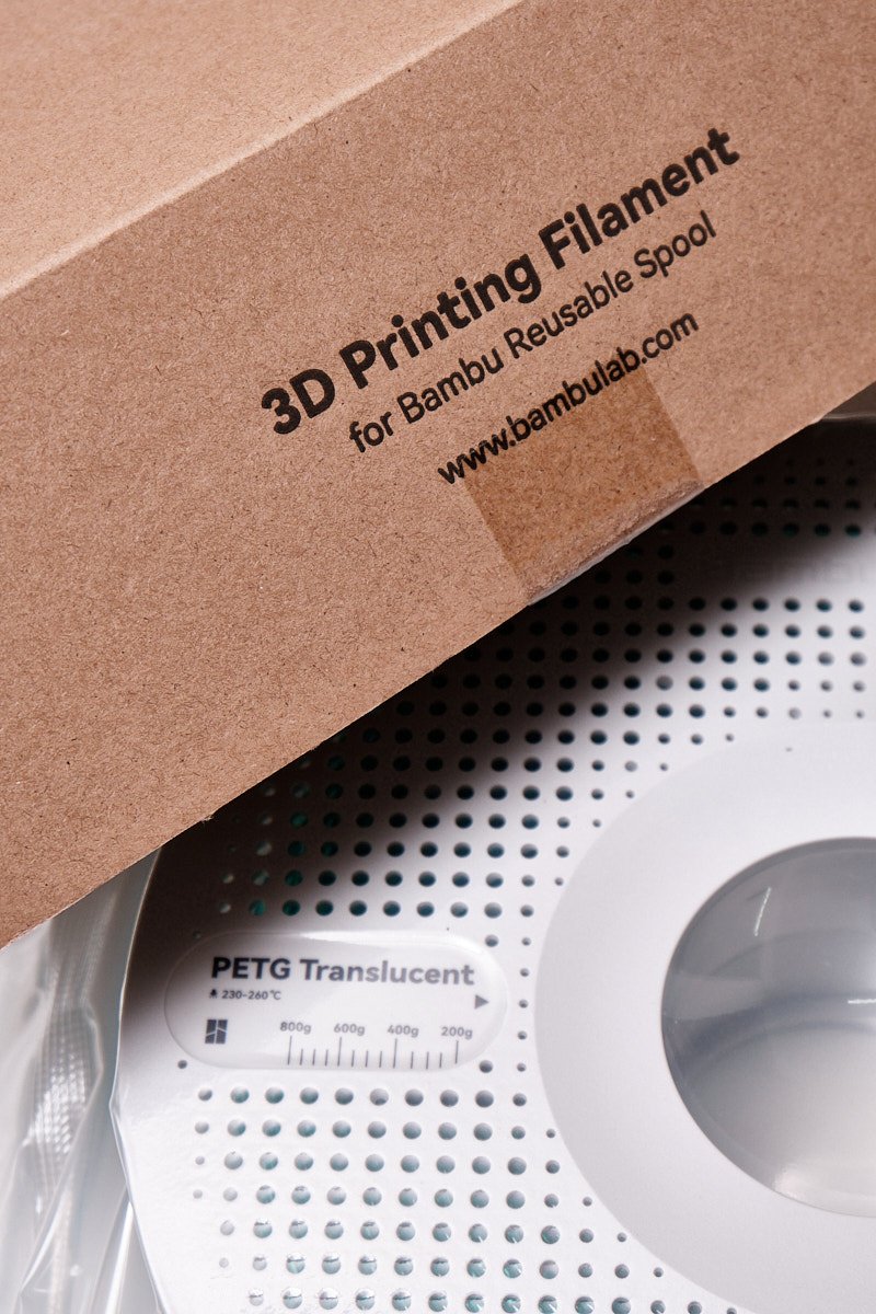 Cardboard packaging of Bambu Lab 3D Printing Filament for Reusable Spool with official website URL.