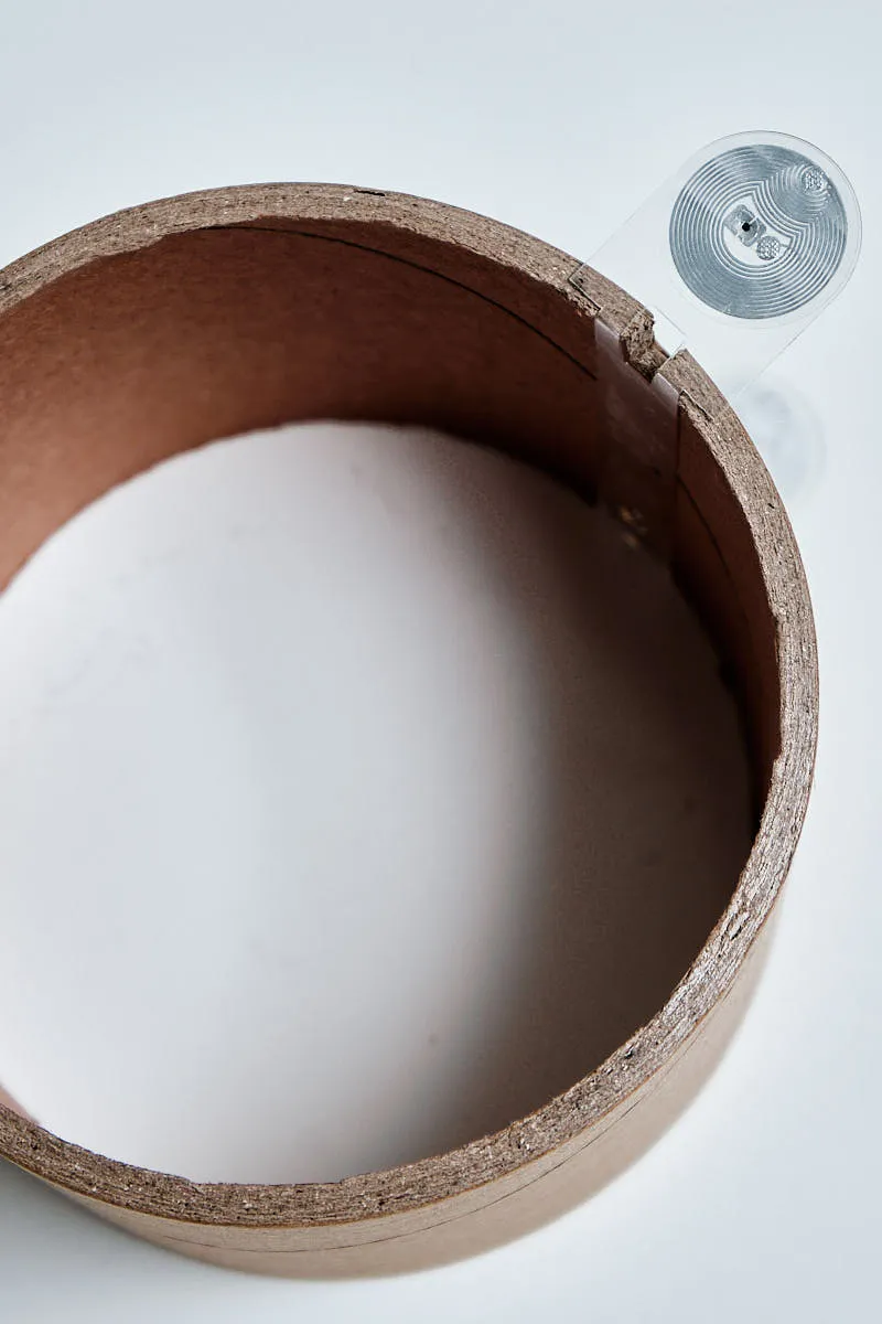 Close-up of Bambu Lab filament cardboard core with integrated RFID tag for automatic material recognition and printer settings sync.