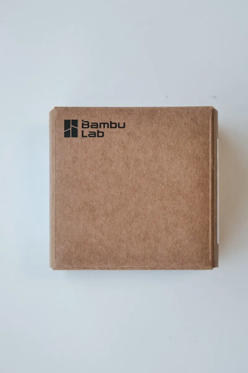 Brown cardboard box for Bambu Lab spare parts featuring the official company logo.