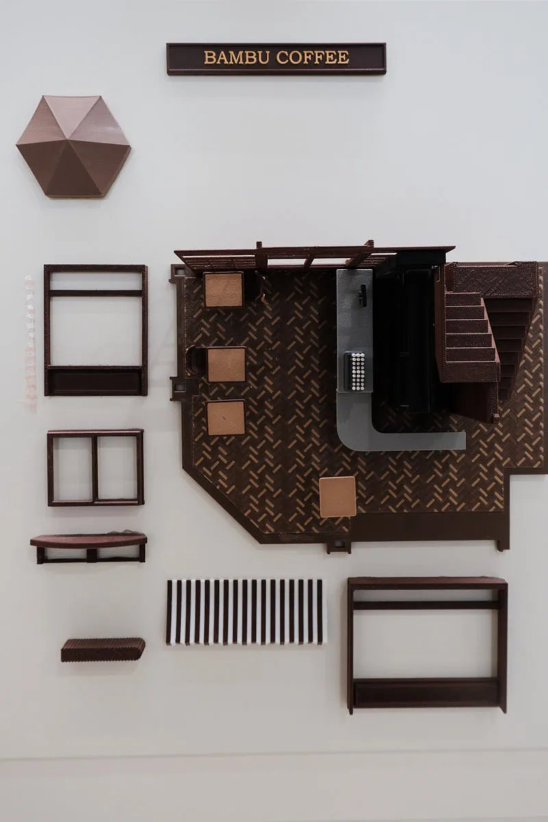 Miniature coffee shop model parts 3D printed with Bambu Lab PLA Basic Brown filament, showing detailed architectural components and smooth surface finish
