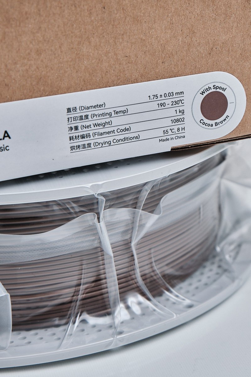 Close-up of the Bambu Lab PLA Basic packaging label for Cocona Brown, showing technical specs like 1.75mm diameter, 190-230&deg;C printing temp, and 1kg net weight.