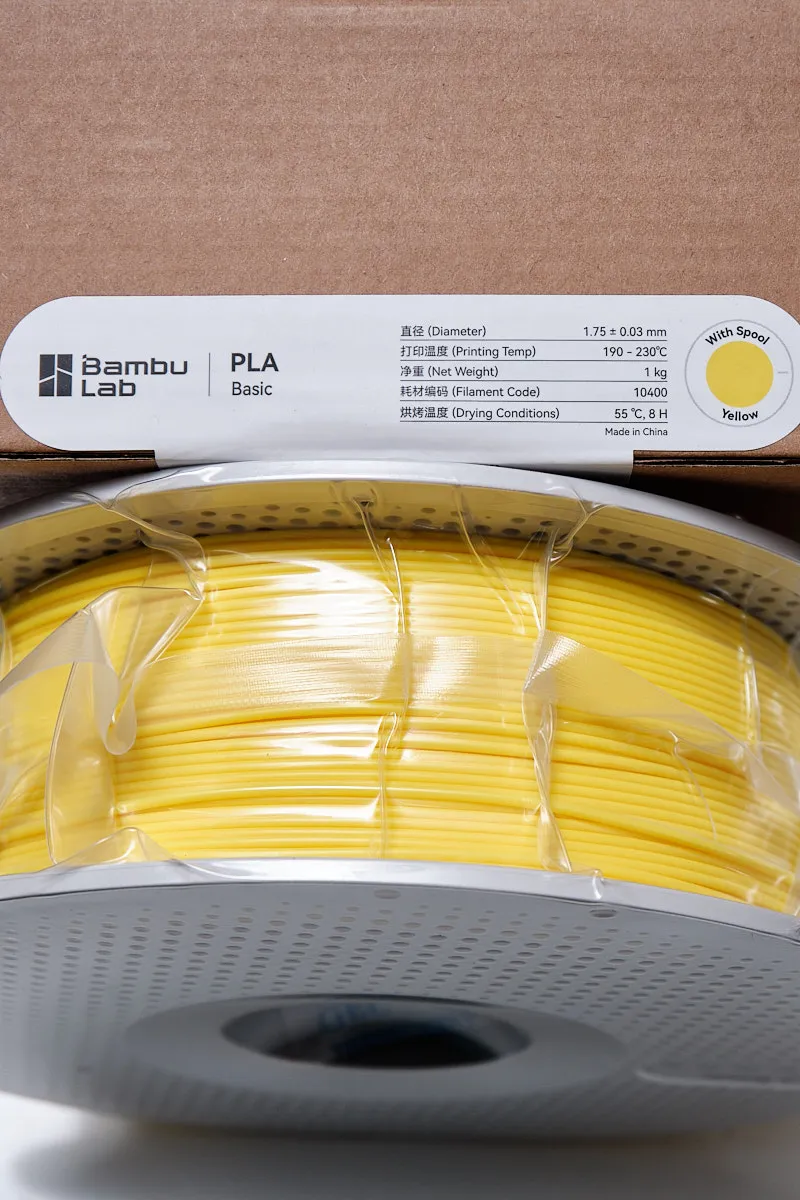 Bambu Lab PLA Basic Yellow 1.75mm 3D printing filament showing label with 1.75mm diameter, 1kg weight, and filament code 10400.