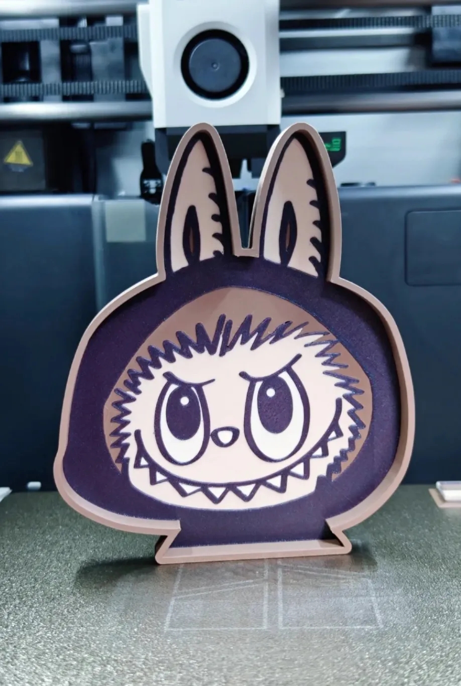 3D printed cartoon character stand made with Bambu Lab PLA Galaxy Purple filament 13602, showing galaxy sparkle effect and clean dual-color detailing