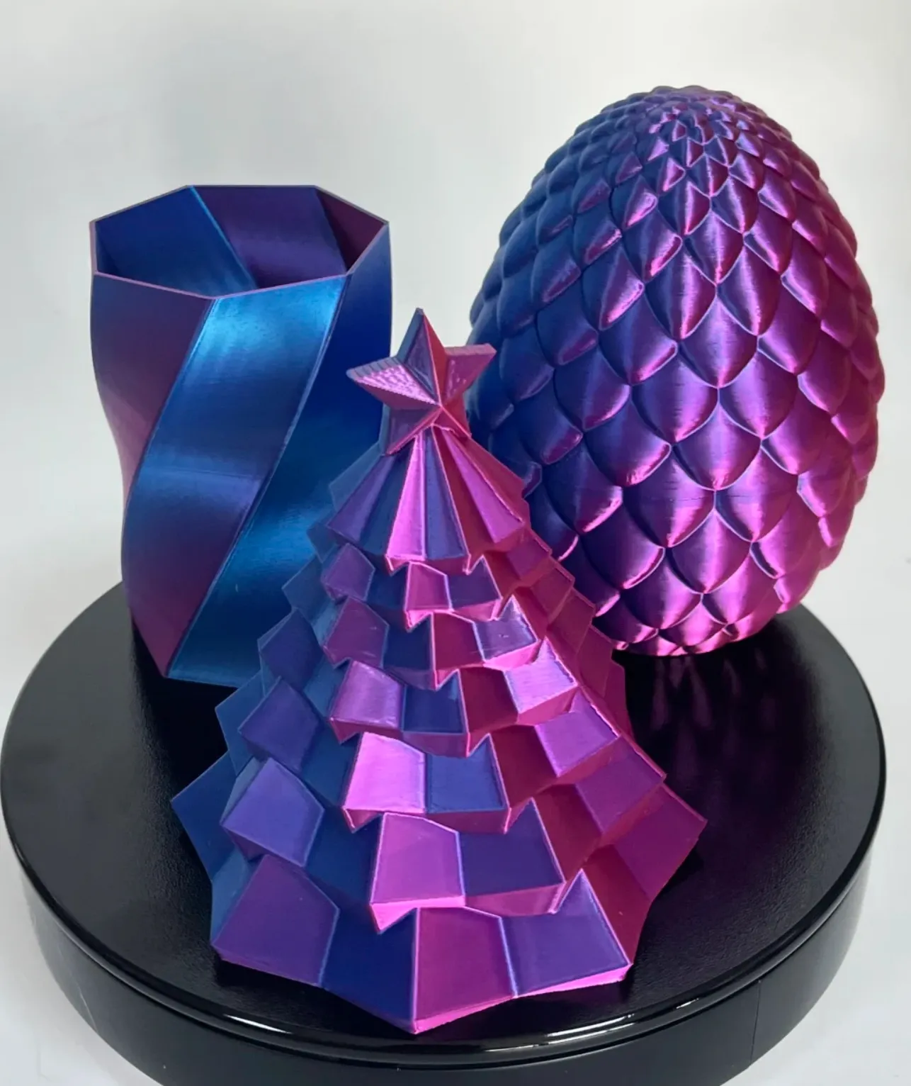 Metallic geometric art objects 3D printed with Bambu Lab PLA Silk Midnight Blaze Filament 13902, showing blue and magenta color-shifting silk finish