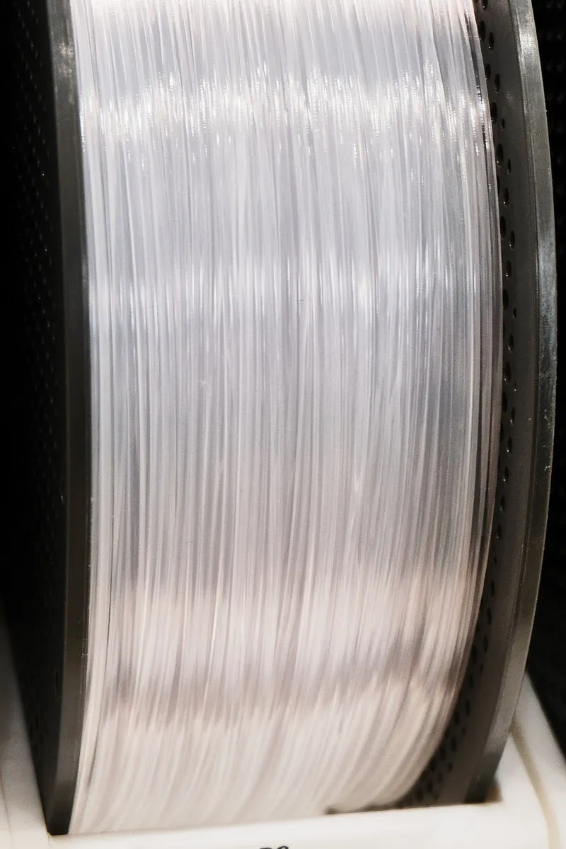 Transparent PC filament wound on spool showing glossy surface and clarity
