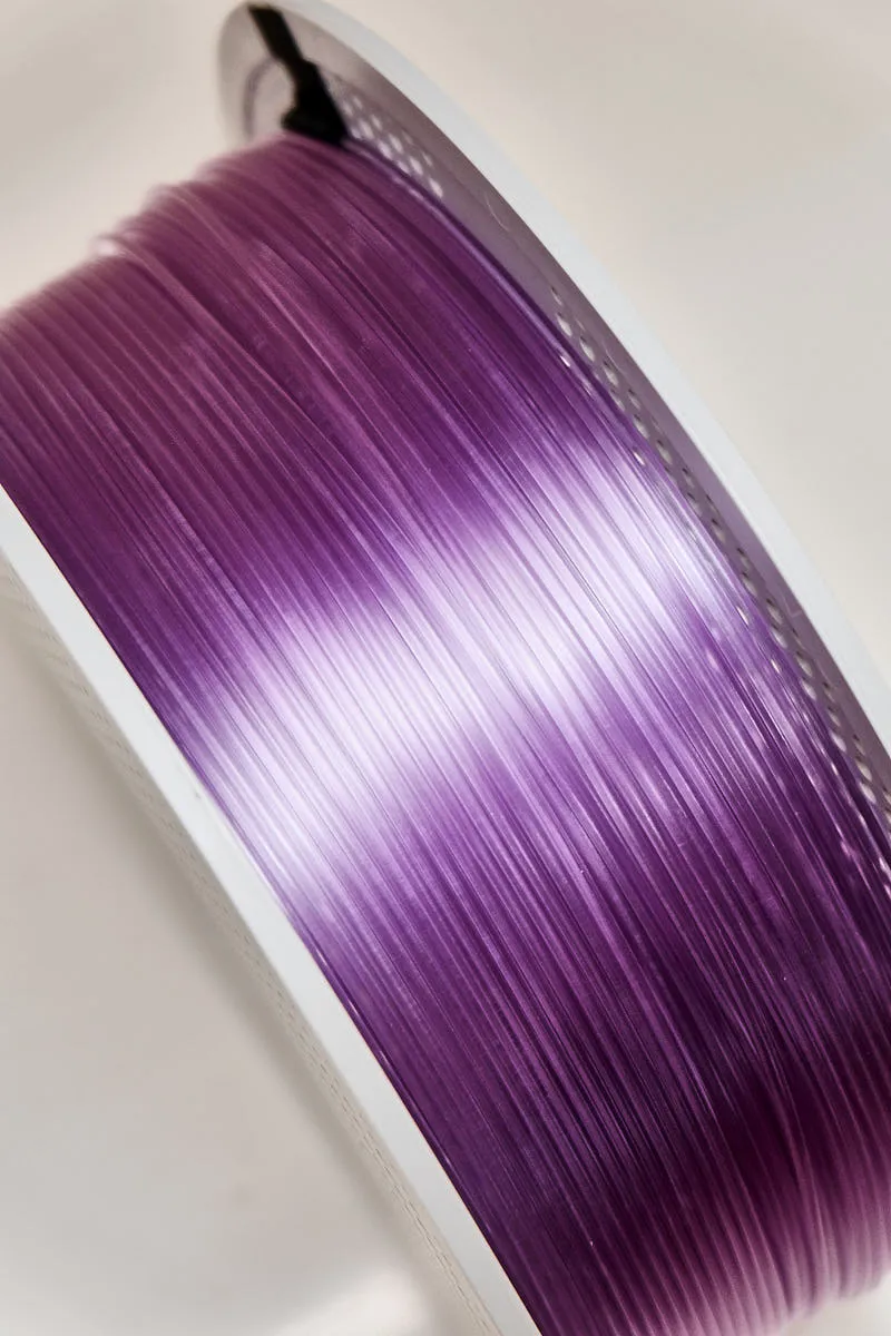 This detailed shot captures the layered structure and glossy translucency of Bambu Lab PETG Translucent Purple Filament (Color Code 32700), emphasizing its smooth surface finish and refined color depth.