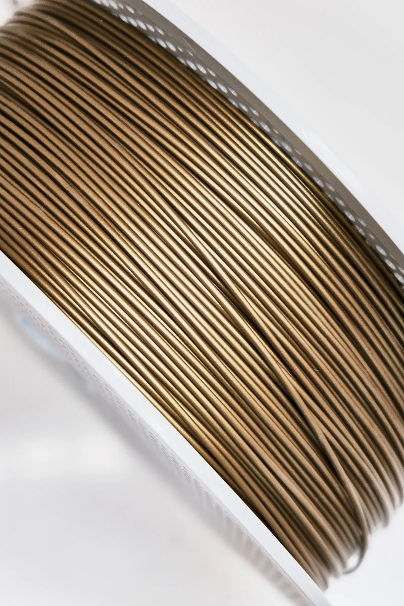 Close-up of bronze PLA Basic filament layers with metallic sheen on spool