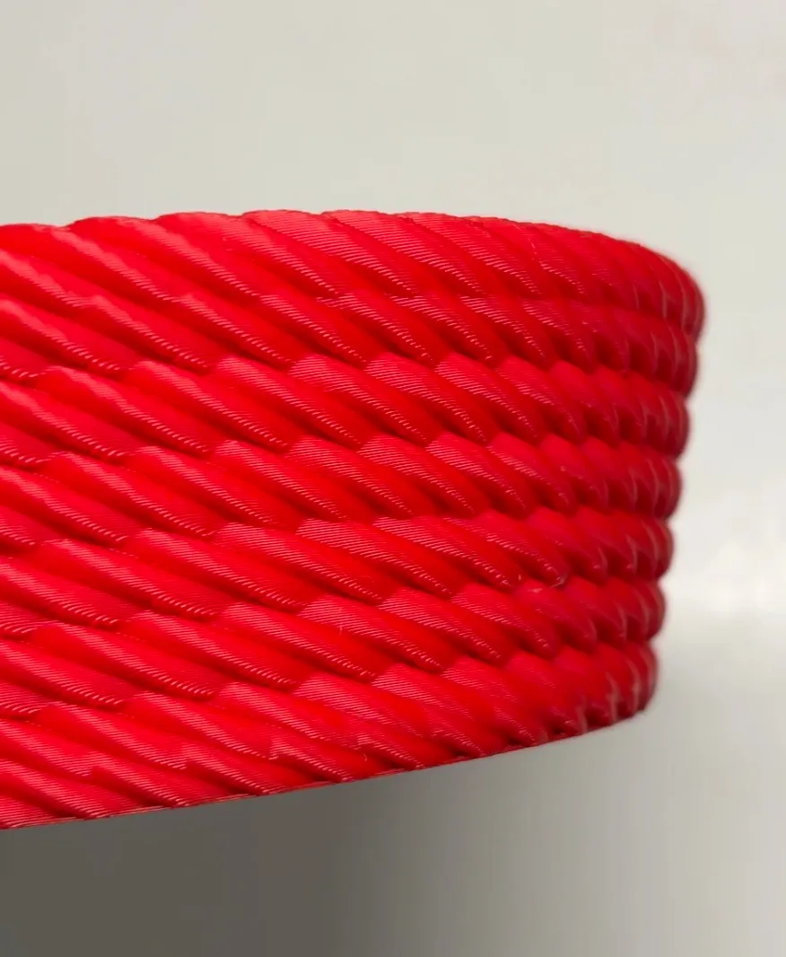 Close-up of red spiral textured 3D print showing layer lines made with Bambu Lab PLA Basic Red filament 10200