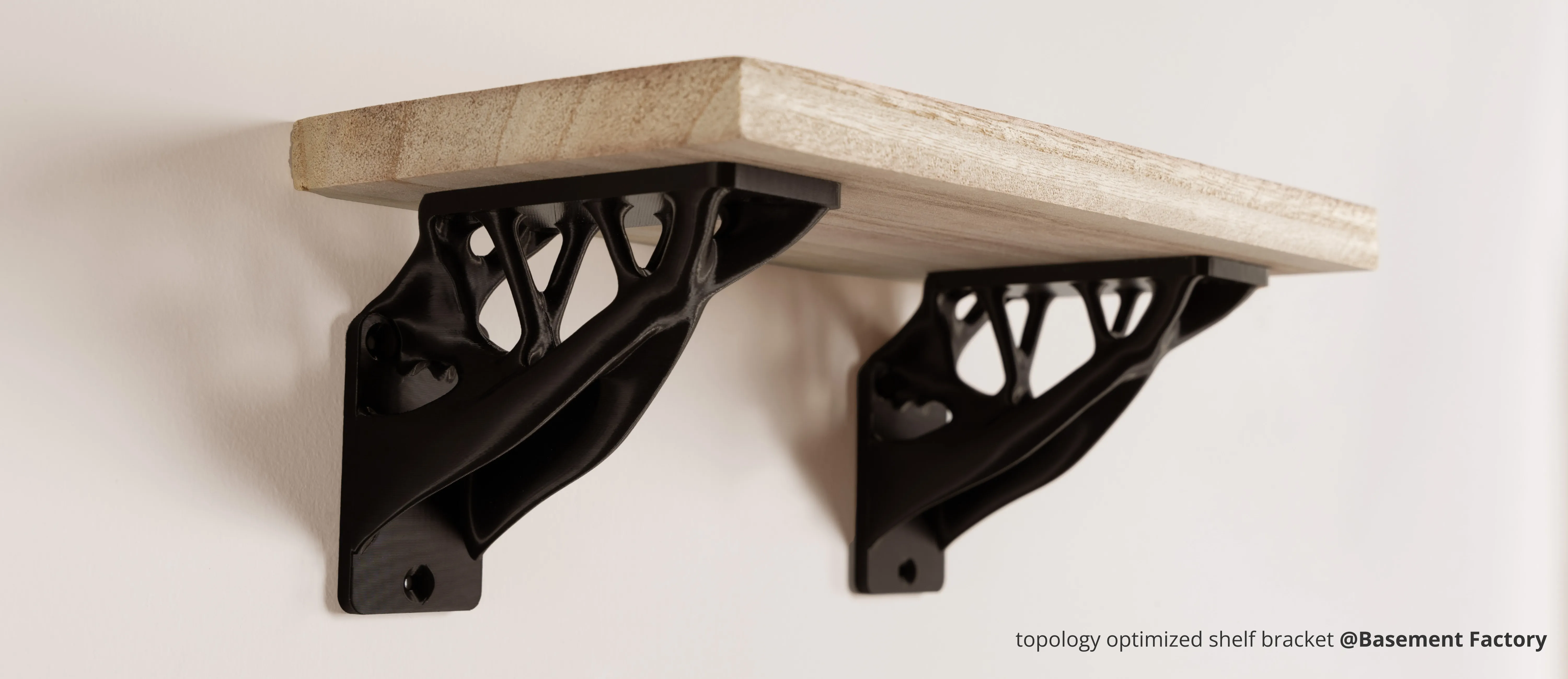 Topology optimized shelf brackets 3D printed with Bambu PLA Tough+ supporting a wooden shelf