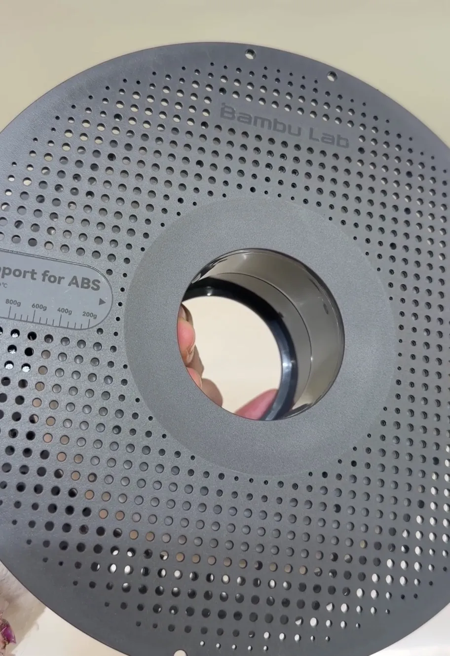 Back view of Bambu Lab ABS support filament spool in white (66100), showing perforated spool design and product label