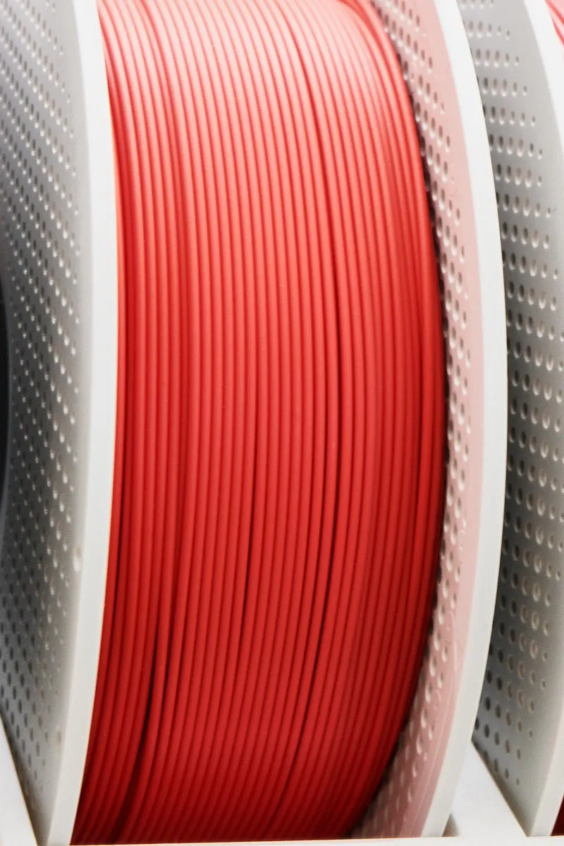 This image shows the angled spool view of Bambu Lab PLA Lite Red Filament 1.75mm 1kg, highlighting smooth extrusion lines and even winding. Color Code 16200 delivers consistent feeding performance for stable and reliable printing.