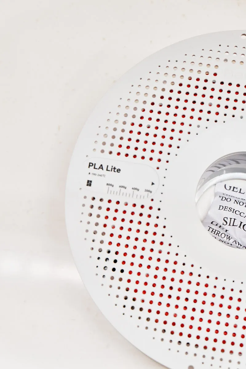 Close-up of PLA Lite label and perforated spool design with visible red filament inside, Bambu Lab PLA Lite Red Filament 1.75mm, Color Code 16200.