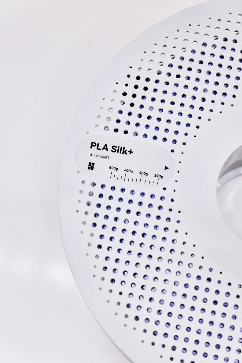 PLA Silk+ label detail on Bambu Lab Purple filament spool showing material type and printing temperature range