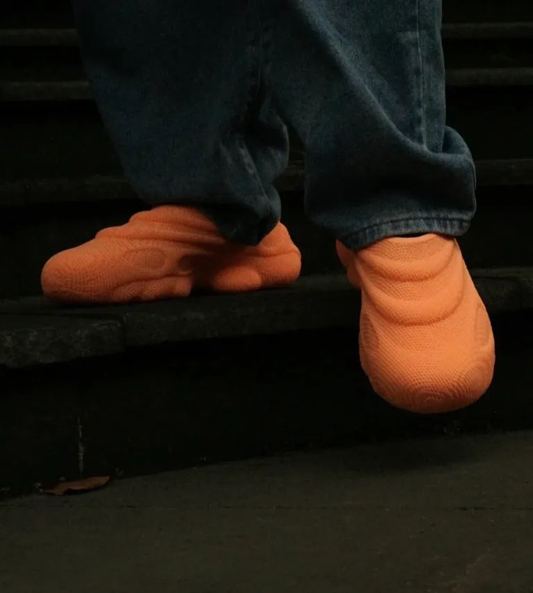 Orange 3D printed shoes made with TPU 85A filament, showing soft flexibility, cushioning structure, and wearable application