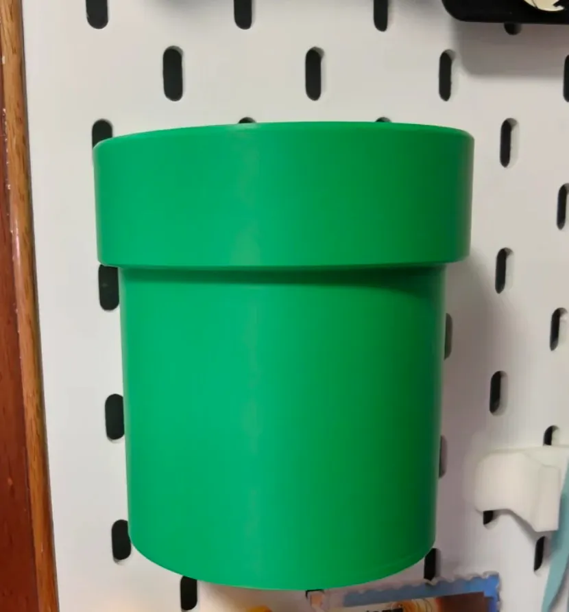 Green cylindrical plant pot 3D printed with Bambu Lab PLA Basic Bambu Green filament 1kg 10501 mounted on a pegboard wall
