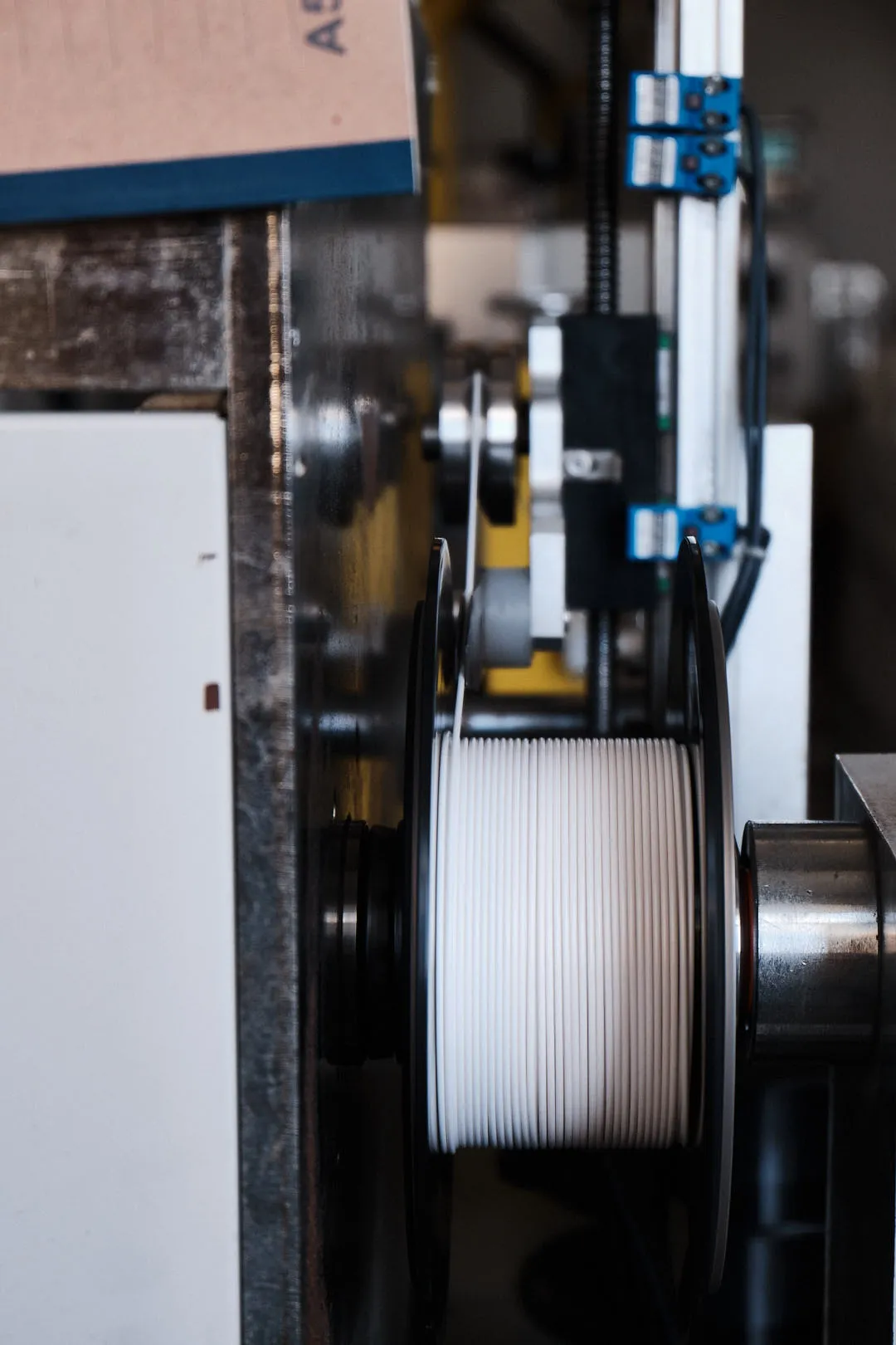 3D printing filament being evenly wound onto a spool during filament manufacturing