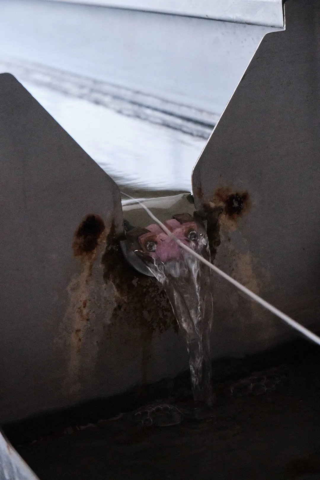 3D printing filament passing through a water cooling channel with guide components to stabilize shape during filament production