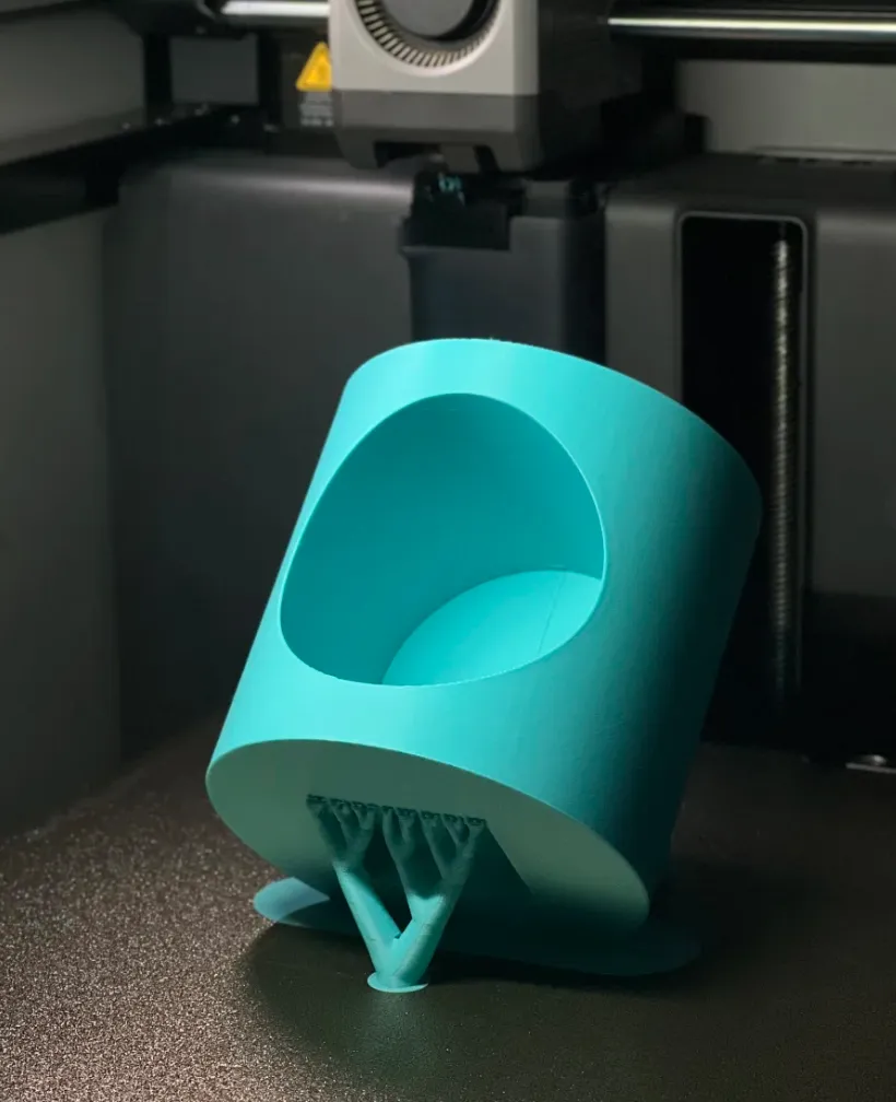 Close-up of turquoise angled container printed with Bambu Lab PLA Basic Turquoise filament 1kg (Color Code:10605) inside a 3D printer chamber