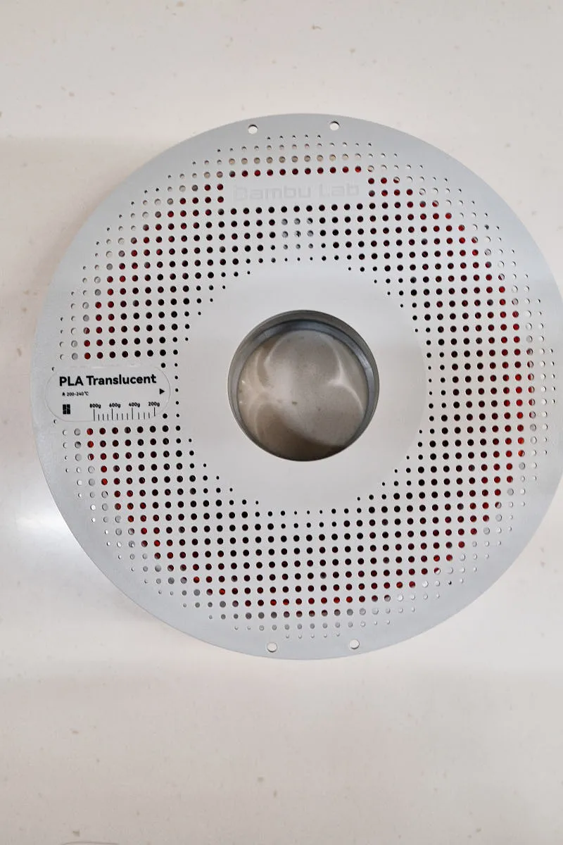 Full view of Bambu Lab Translucent Red PLA filament spool 13210 with evenly wound translucent red filament