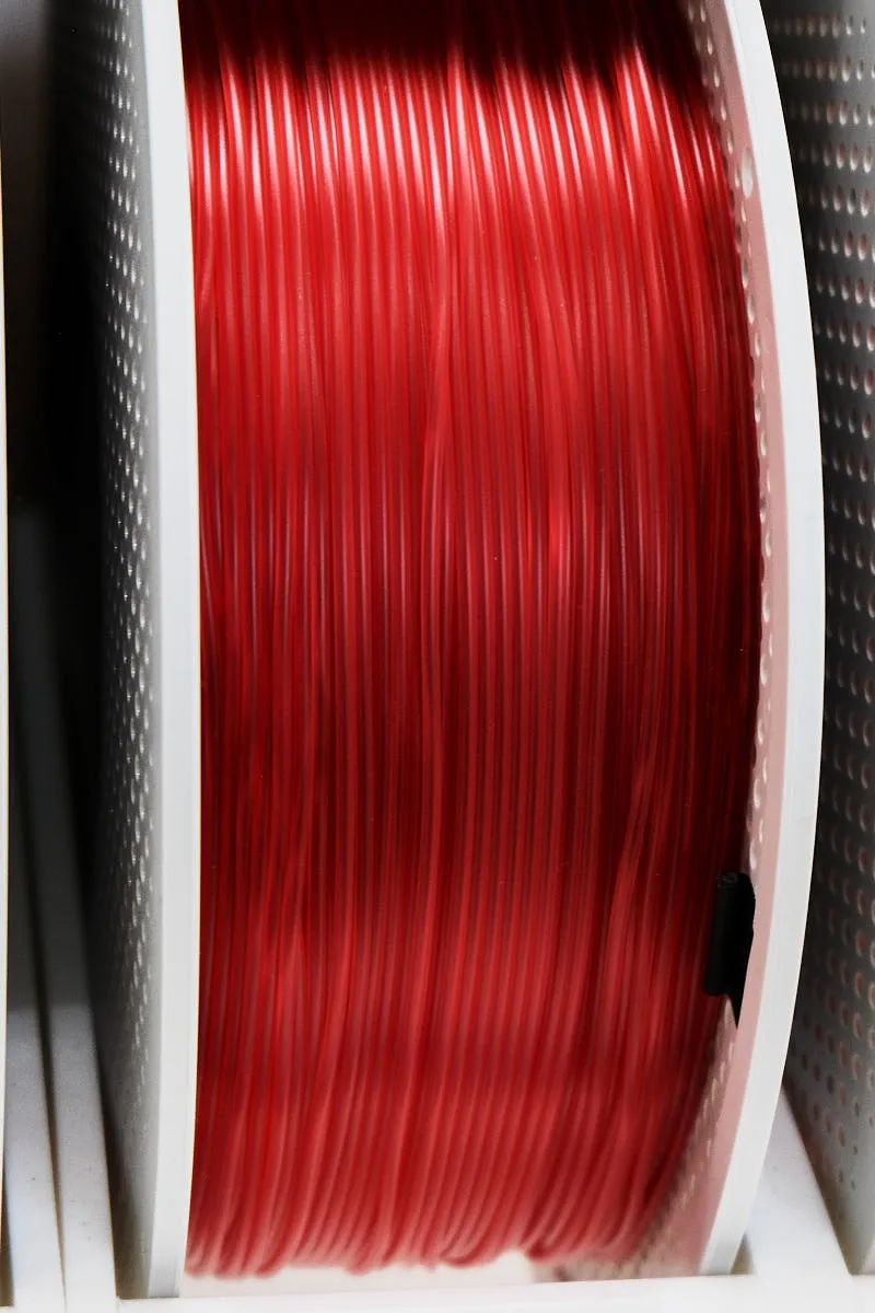 Side view of Bambu Lab Translucent Red filament 13210 on spool, highlighting filament thickness and light transmission