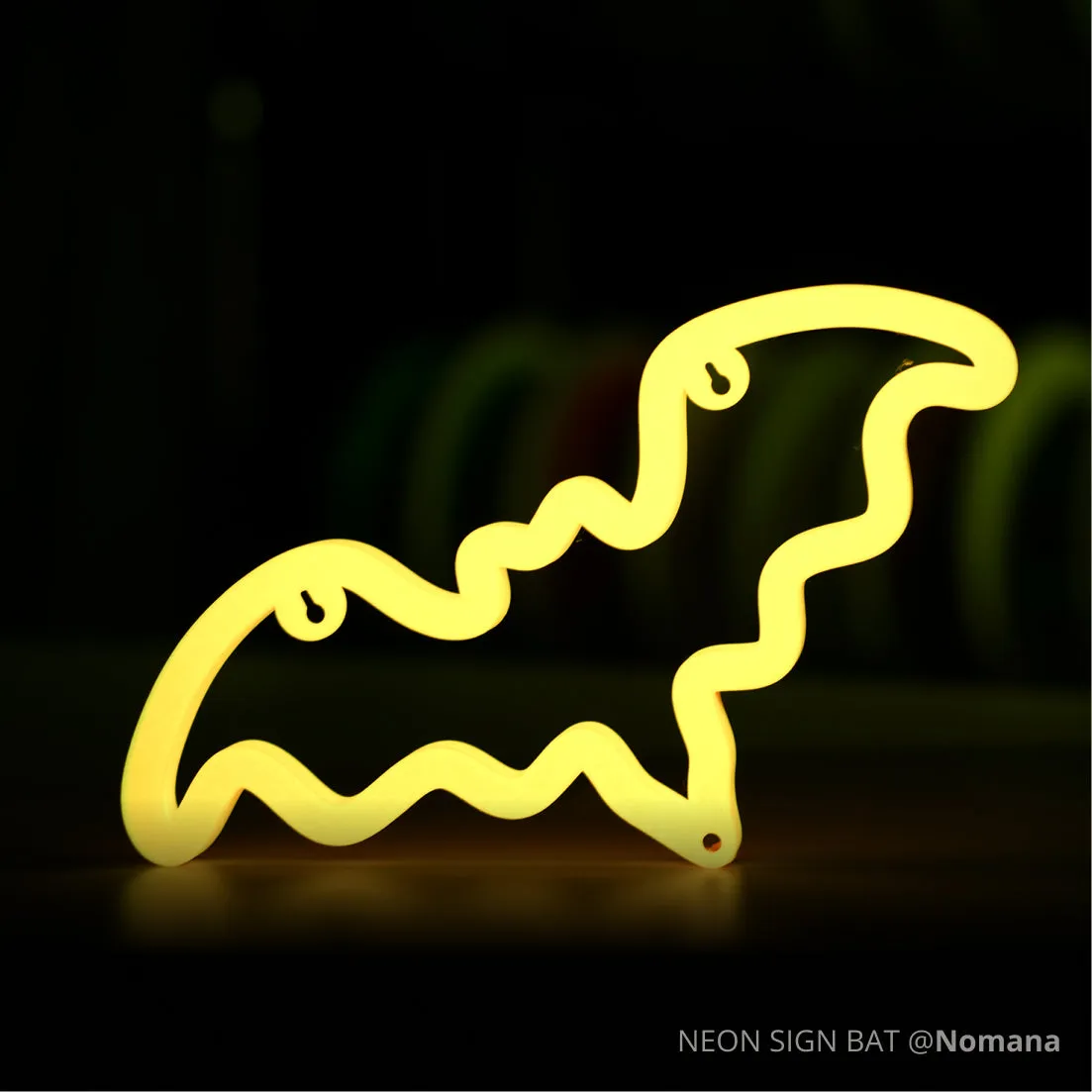 Glow-in-the-dark bat-shaped neon sign 3D printed with Bambu PLA Glow filament on dark background