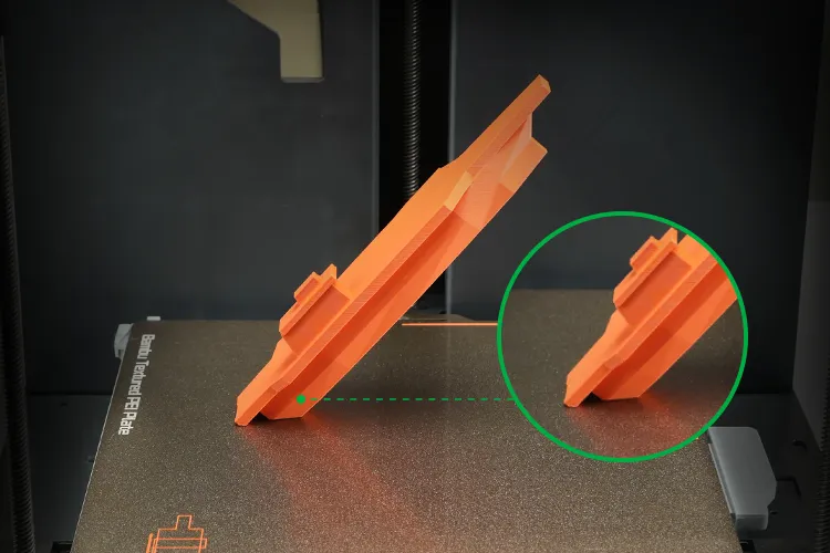 Angled 3D printed part on textured PEI build plate showing improved base stability and adhesion