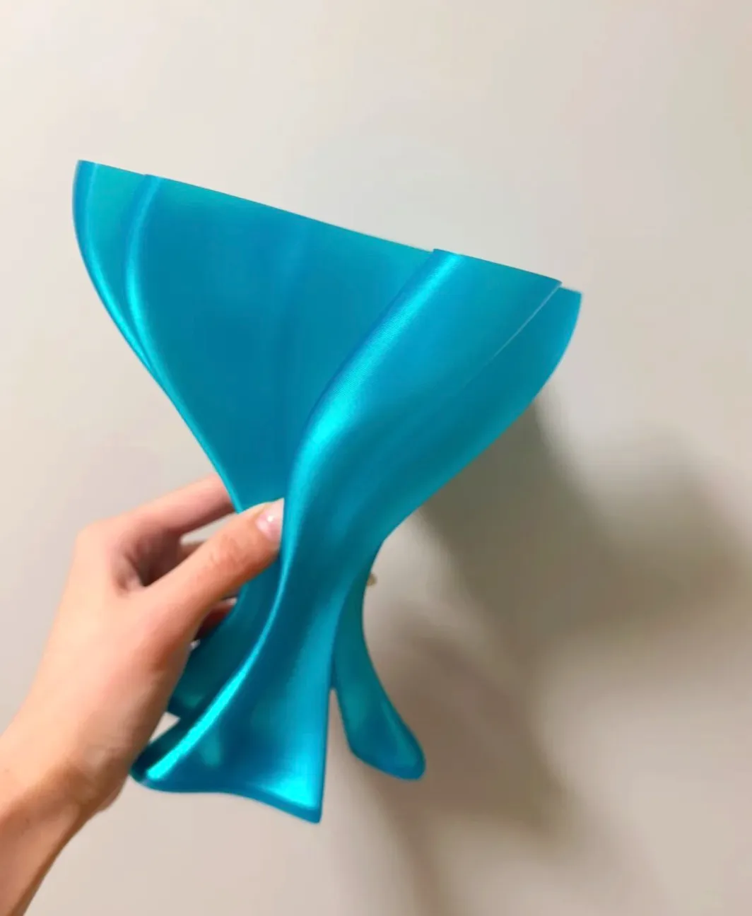 Handheld sculptural print made with Bambu Lab PLA Translucent Teal Filament with Spool 13612 showing smooth curves and soft light diffusion.