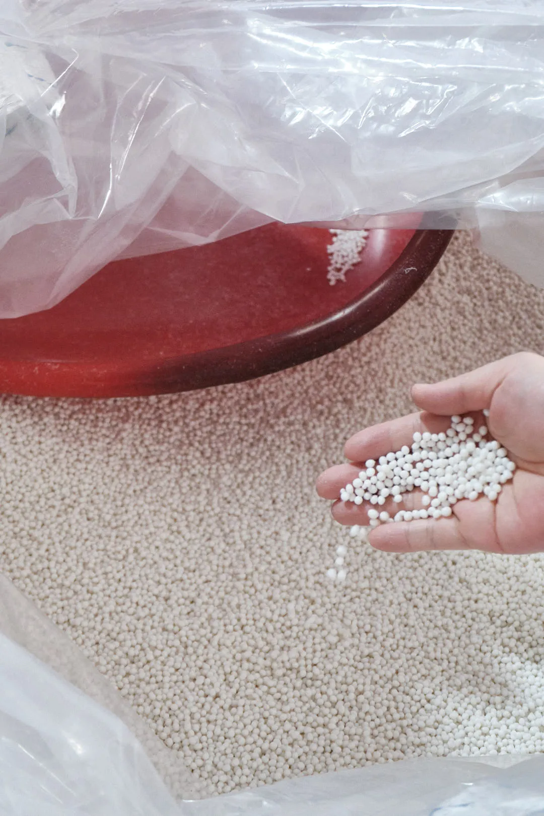 Raw white plastic pellets used as base material for 3D printing filament manufacturing