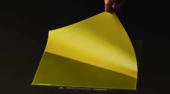 Hand lifting flexible yellow PEI build plate sheet from Snapmaker U1 print bed