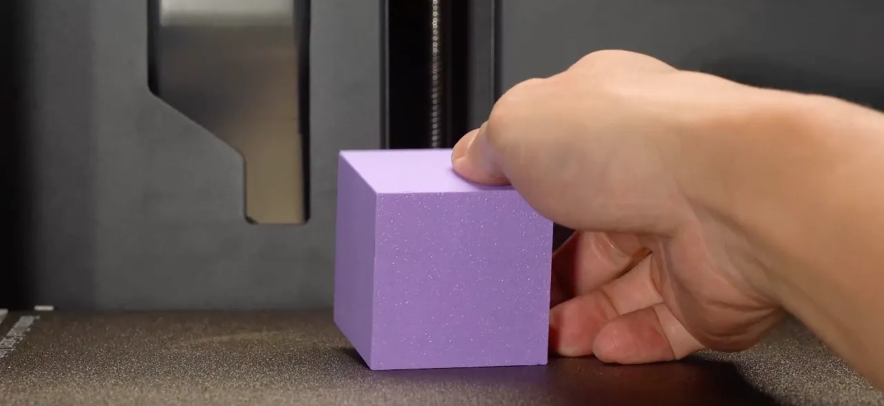 Textured bottom surface on 3D printed cube created by textured PEI build plate, showing fine matte grain pattern