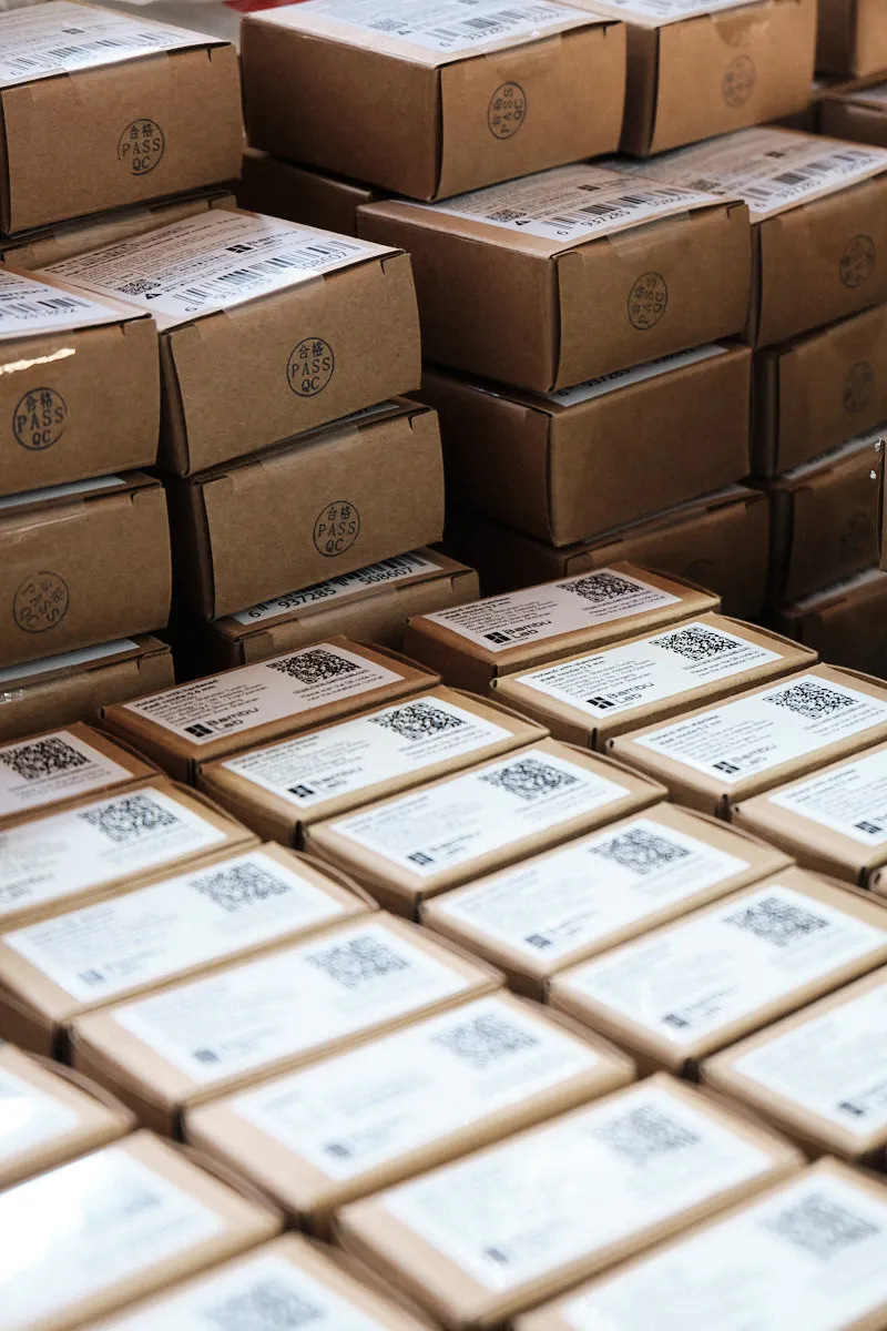 Stacked cardboard boxes with QC pass labels and QR codes, prepared for wholesale shipping and OEM order fulfillment