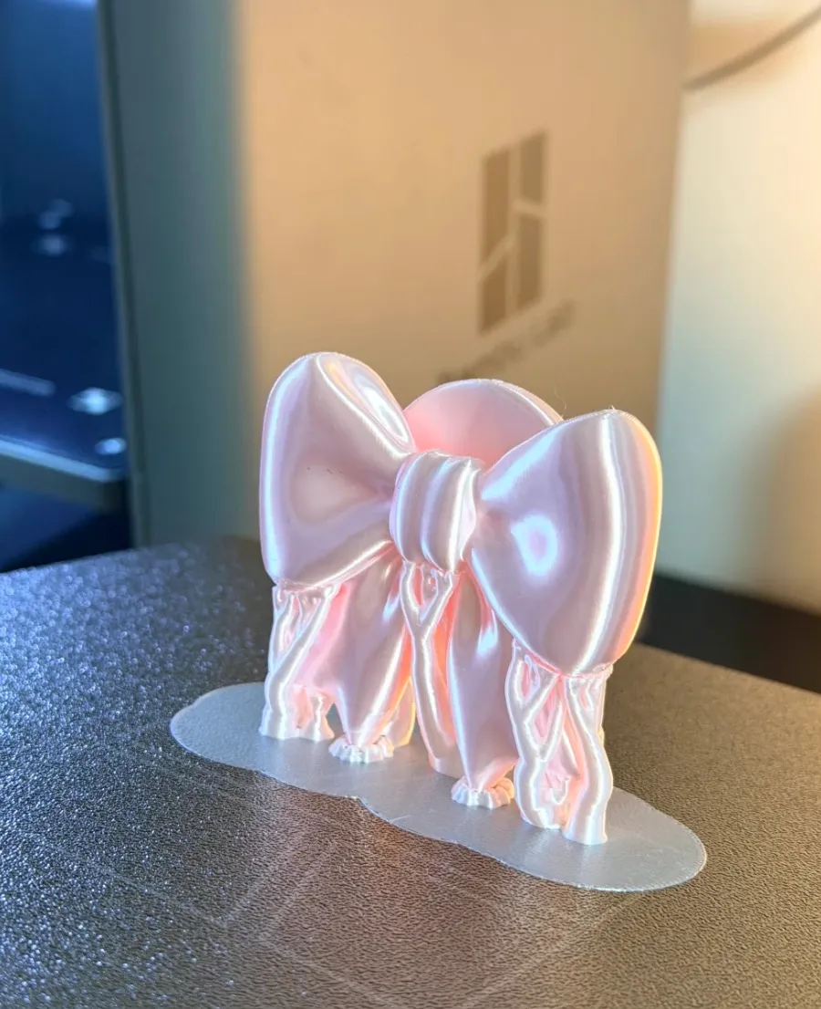 3D printed decorative bow on build plate using Bambu Lab PLA Silk+ Pink Filament 1.75mm 1kg/Spool Color Code 13207