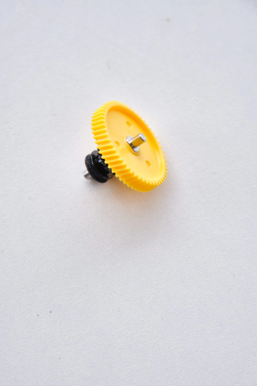 Bambu Lab hardened steel extruder gear assembly angled view with yellow gear and metal shaft