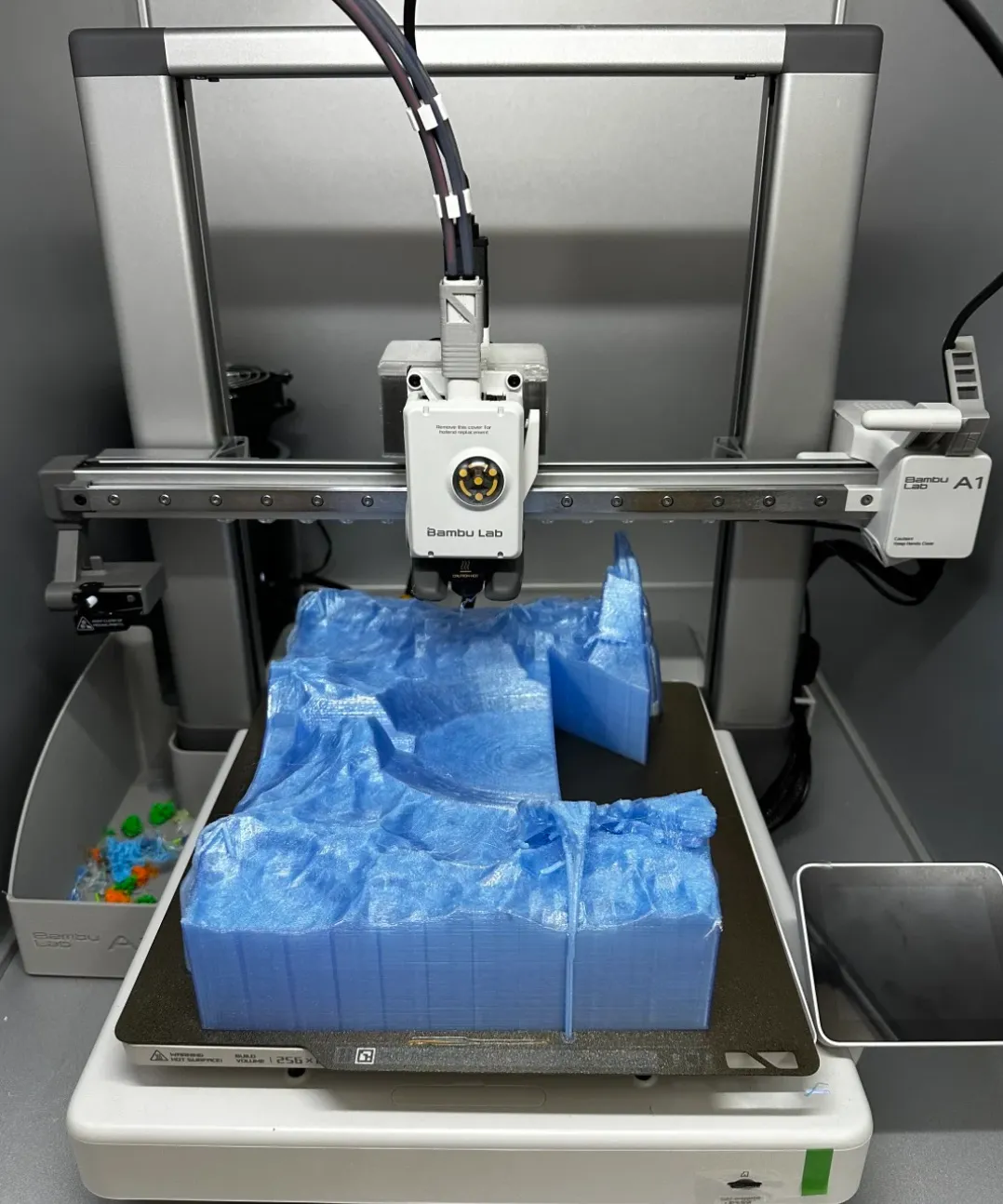 Bambu Lab A1 printer producing a large model using Bambu Lab PETG Translucent Light Blue Filament Color Code 32600 on textured build plate.