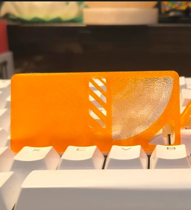 Translucent orange test panel printed with Bambu Lab PETG Translucent Orange Filament Color Code 32300 placed on white keyboard showing light diffusion.