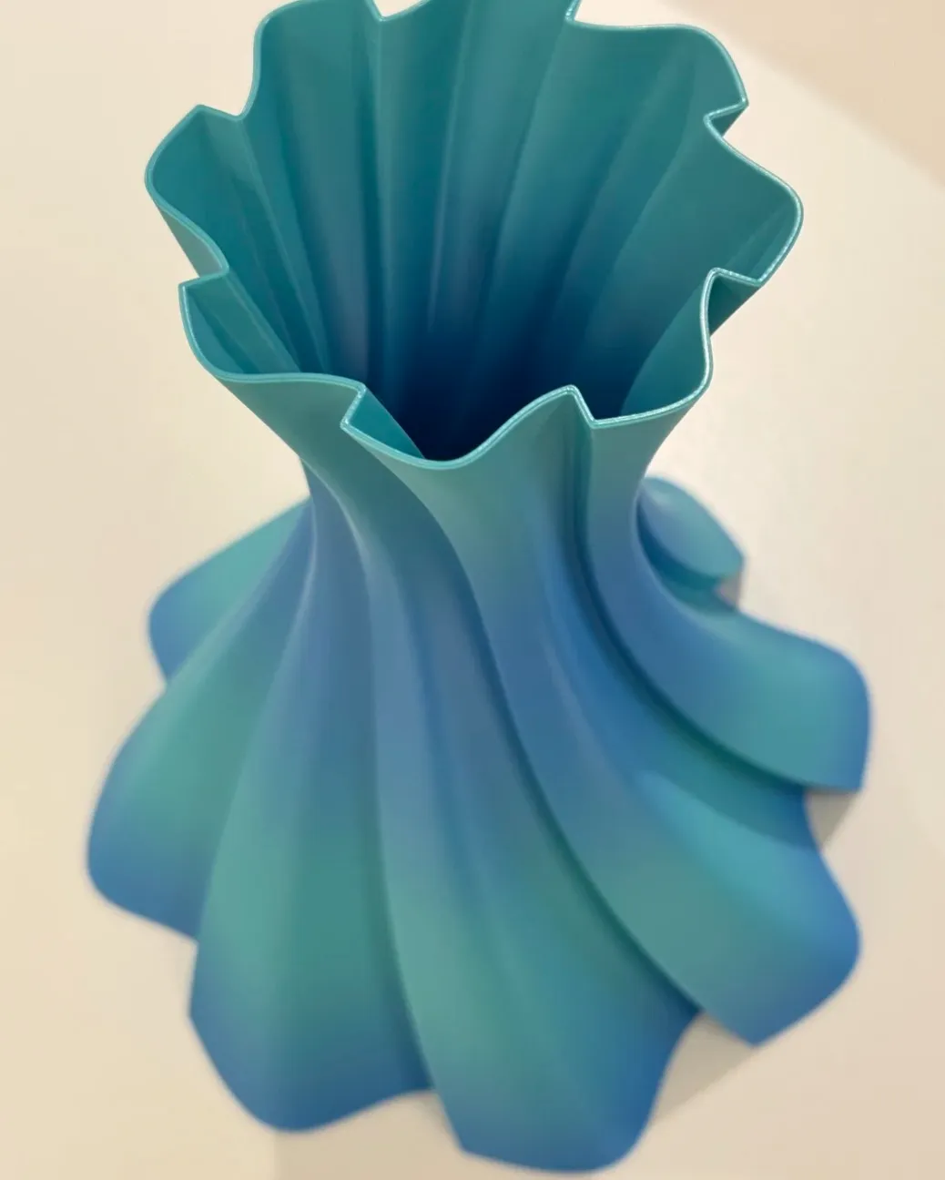 Top view of a spiral vase 3D printed with Bambu Lab PLA Basic Gradient Ocean to Meadow Filament with Spool, showing smooth blue-to-green gradient transition, Color Code 10902.