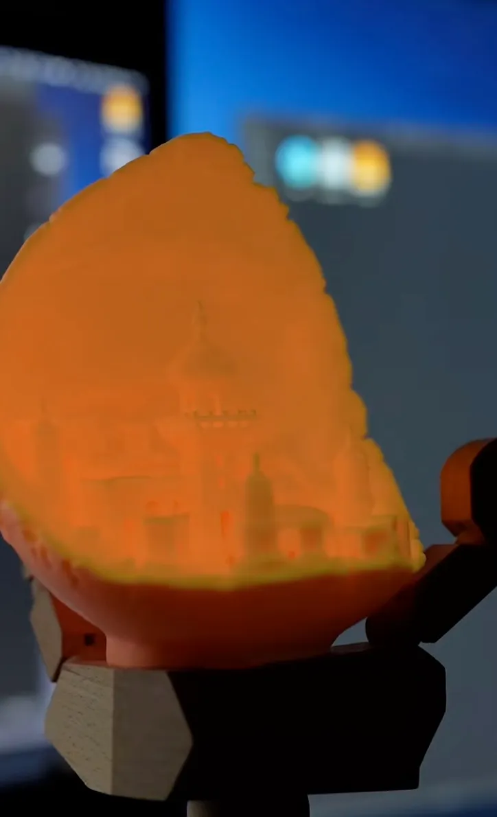 Close-up of a glowing city relief print made with Bambu Lab PLA Glow Orange Filament 1.75mm 1kg/Spool (Color Code:15300), showing soft light diffusion and layered relief depth