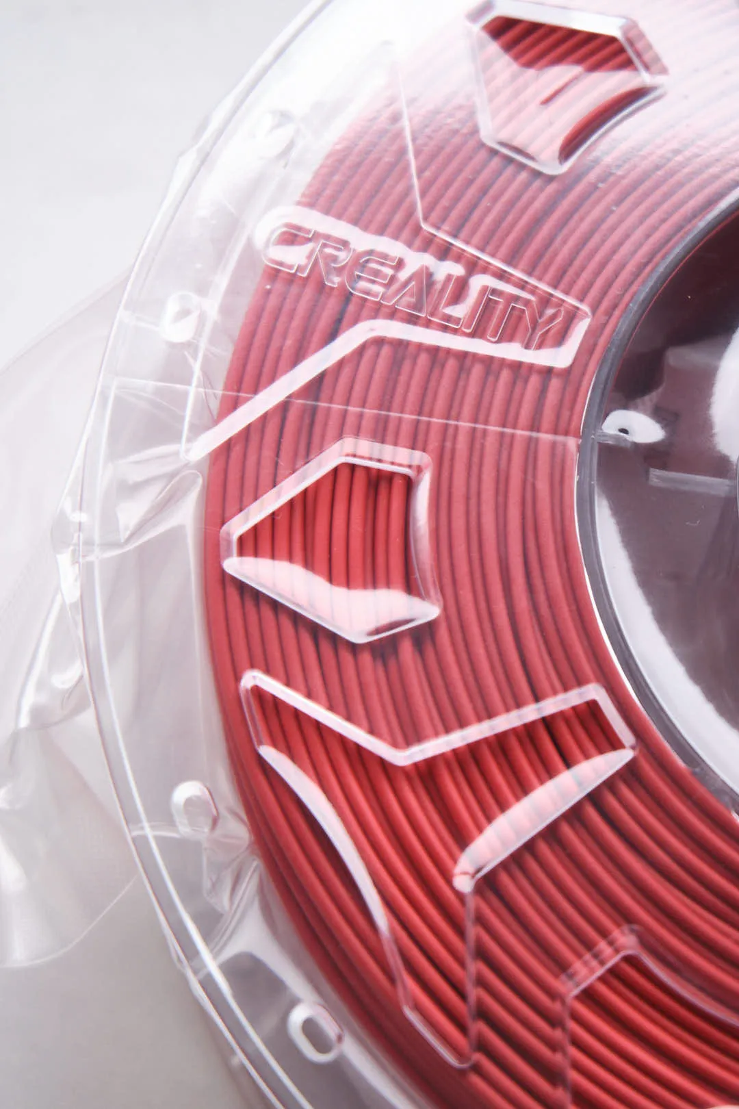 close-up of Creality logo on CR-PLA Carbon Red filament spool with red filament lines