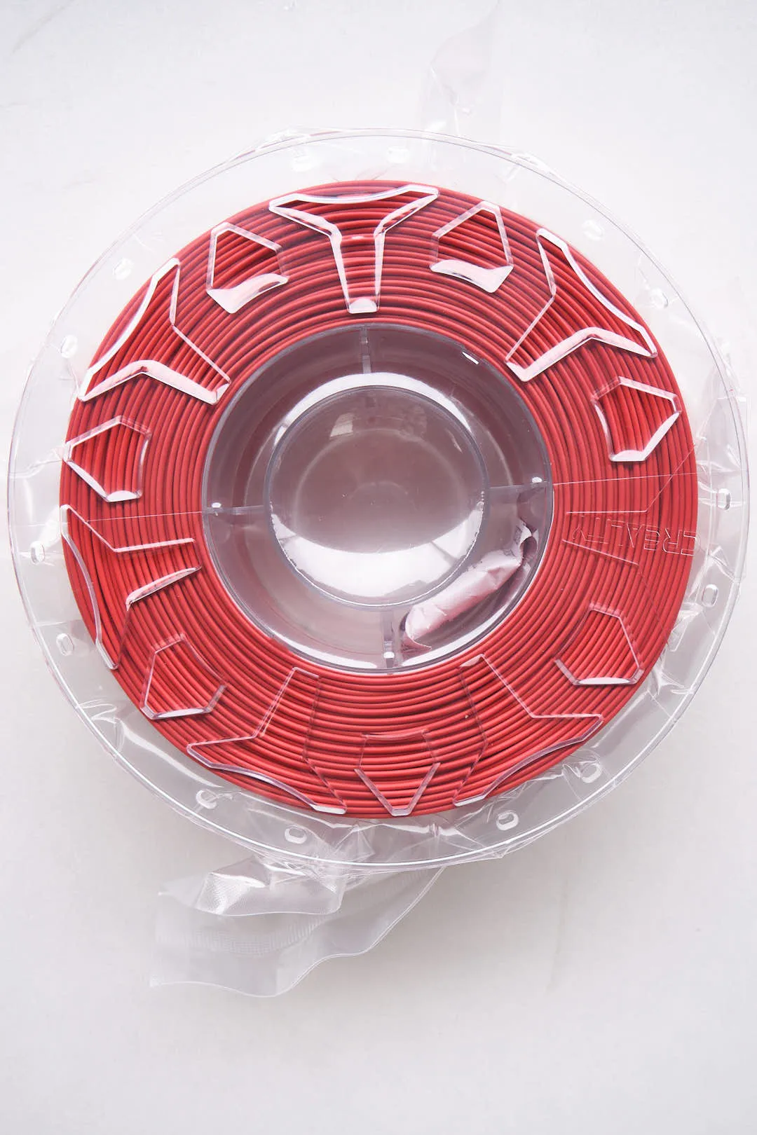 top view of Creality CR-PLA Carbon Red filament 1.75mm 1kg neatly wound on spool inside clear packaging