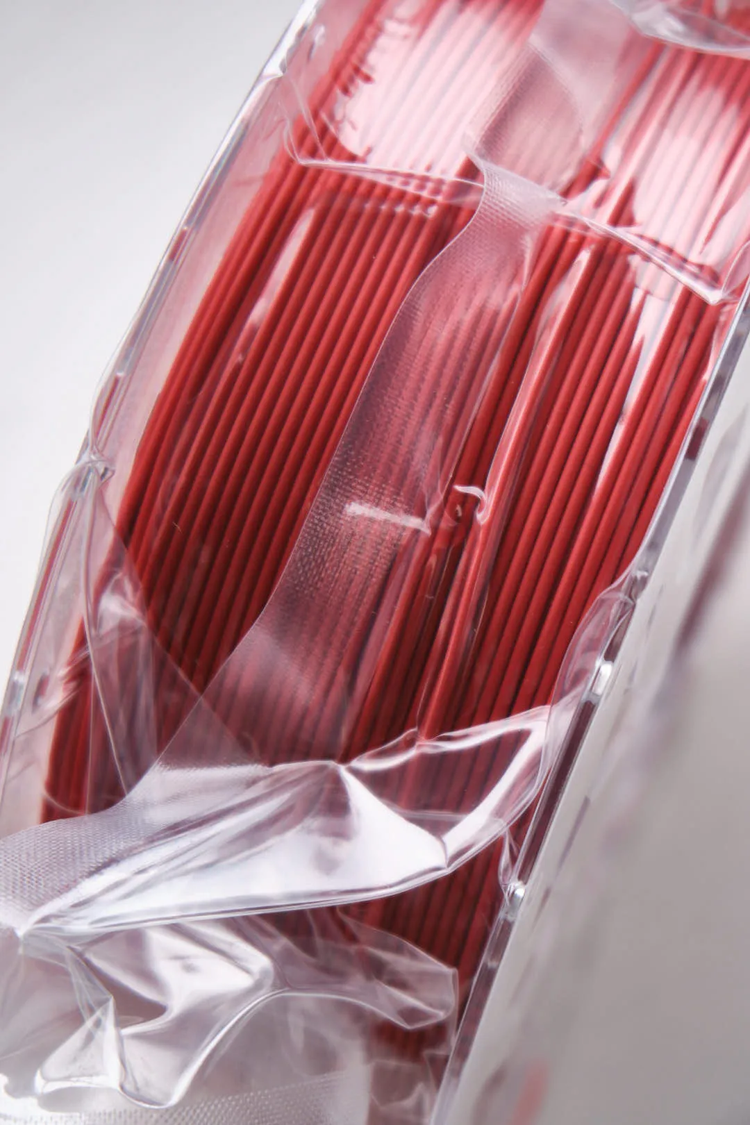 angled view of Creality CR-PLA Carbon Red filament 1.75mm 1kg inside vacuum sealed plastic