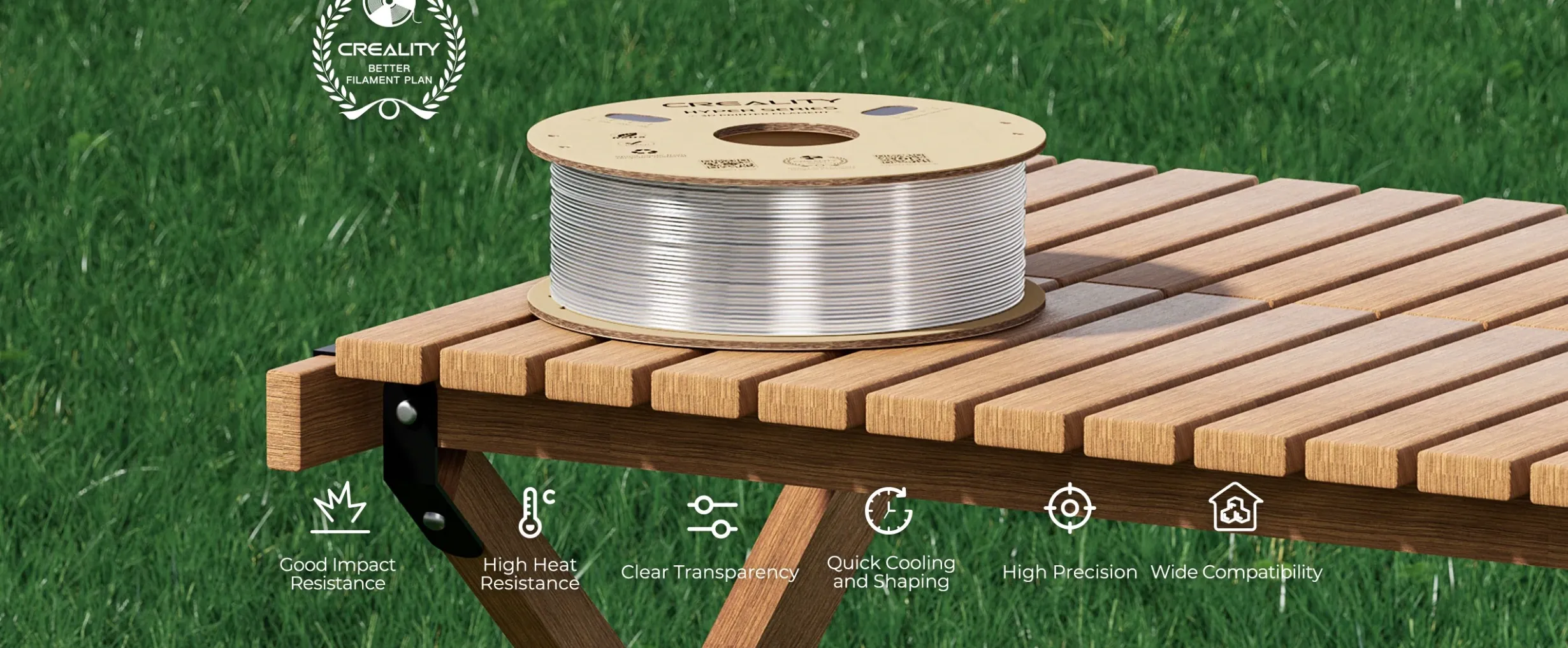 Creality Hyper PC Clear Filament spool placed on wooden table with icons showing impact resistance heat resistance and precision