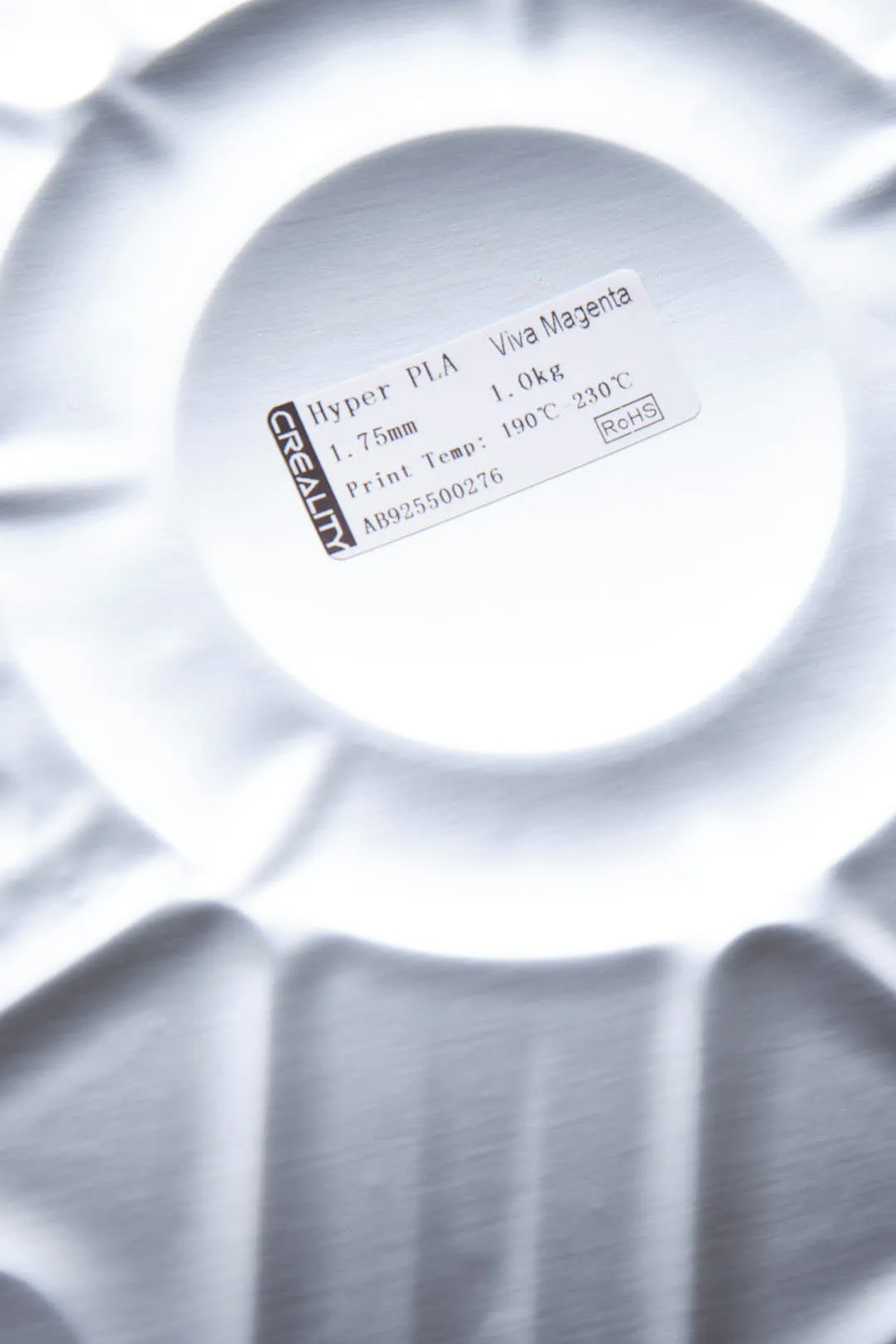 Close-up of Creality Hyper PLA RFID Viva Magenta filament spool label visible through packaging showing specifications