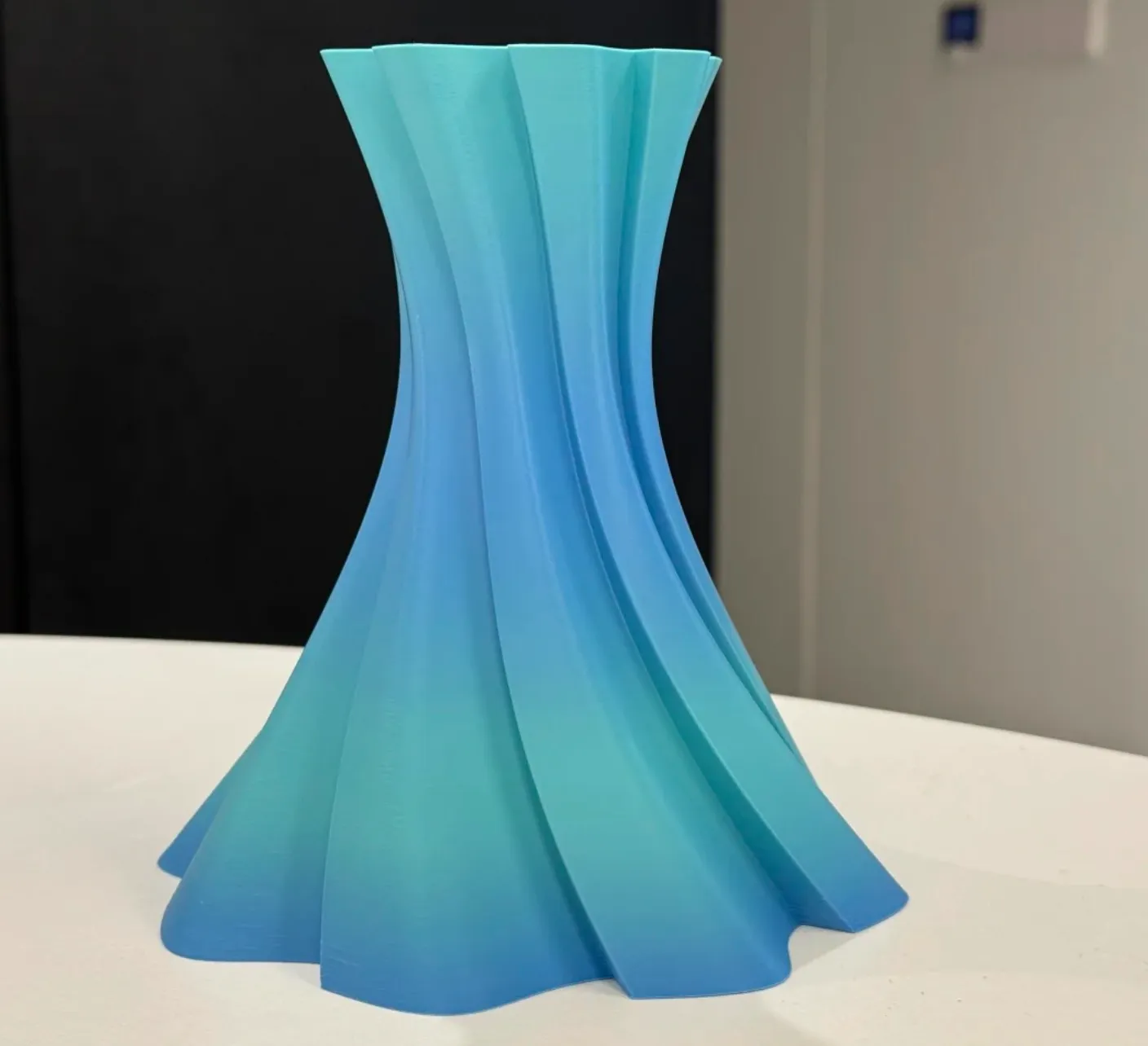 Curved twist vase printed with Bambu Lab PLA Basic Gradient Ocean to Meadow Filament with Spool showing soft ocean blue to meadow green gradient, Color Code 10902.