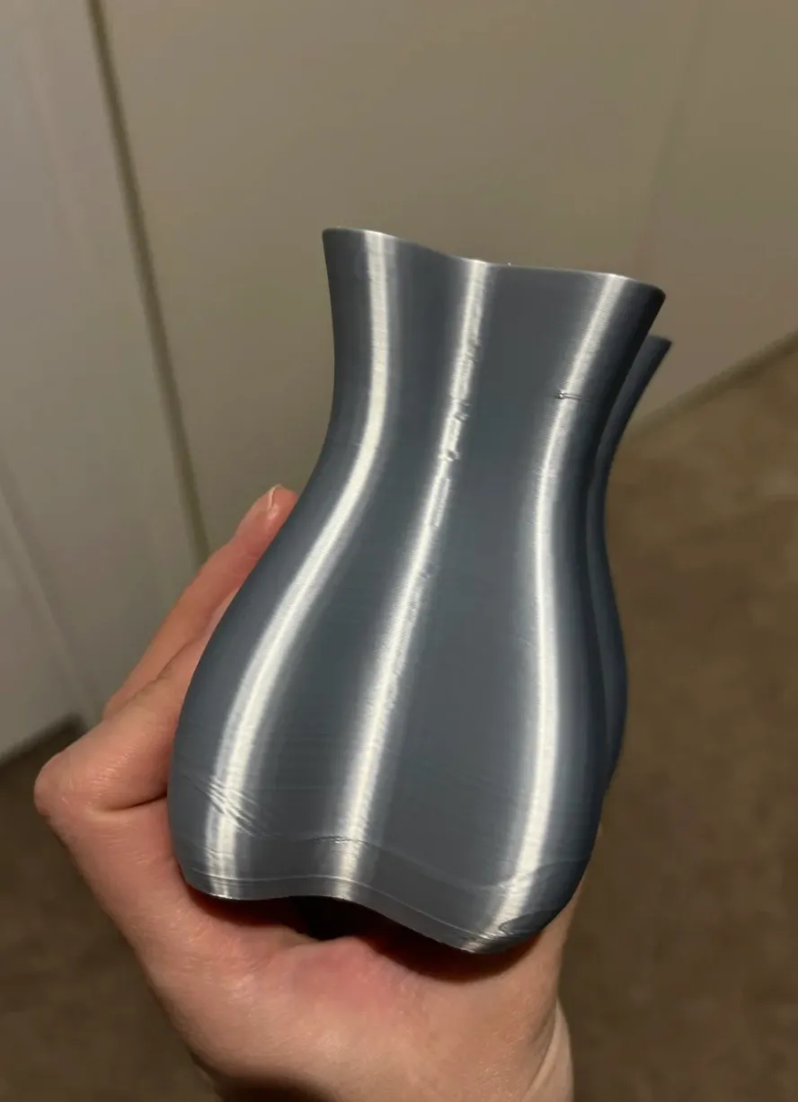 Curved vase model printed with Bambu Lab PLA Silk+ Titan Gray Filament 1.75mm 1kg/Spool Color Code 13108 showing smooth silk sheen and metallic gray finish