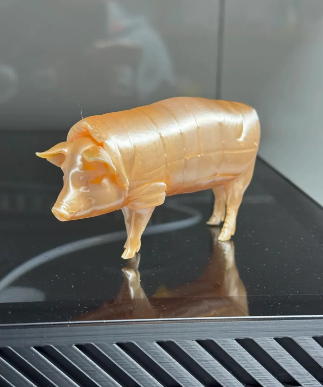 3D printed pig figurine using Bambu Lab PLA Silk+ Champagne Filament 1.75mm (Color Code 13404) placed on build plate.