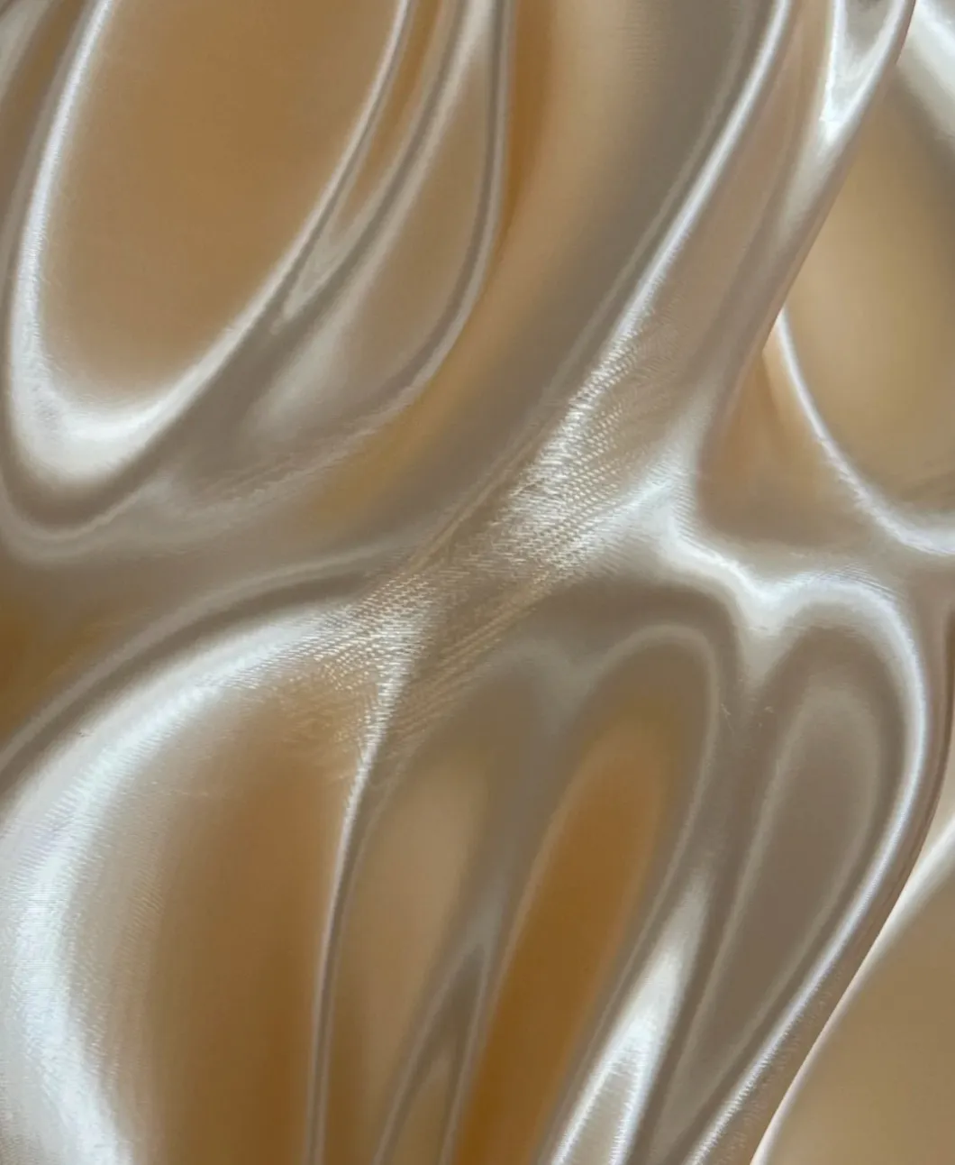 Close-up surface detail of Bambu Lab PLA Silk+ Champagne Filament 13404 showing fine layer lines and silk-like metallic gloss.