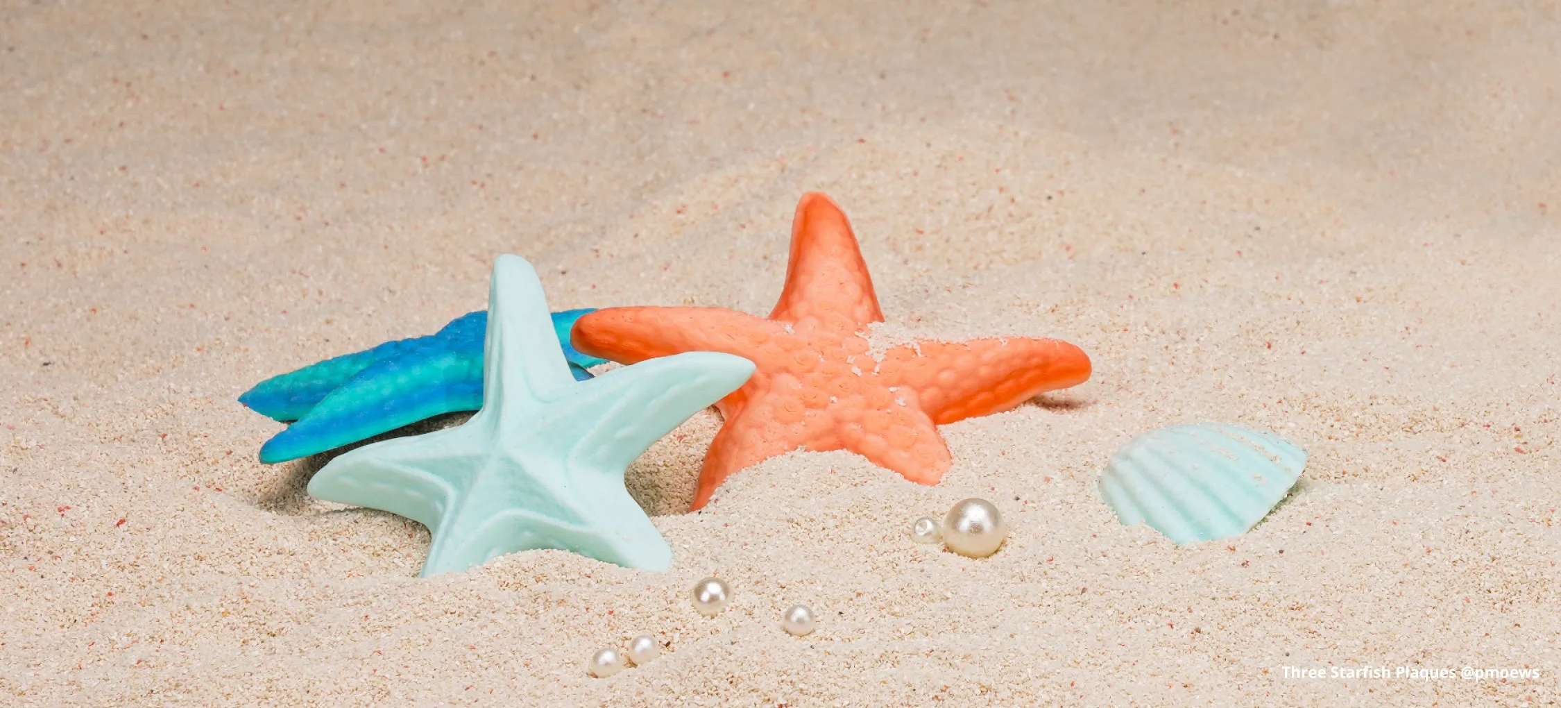 3D printed starfish decorative models in gradient PLA placed on sand